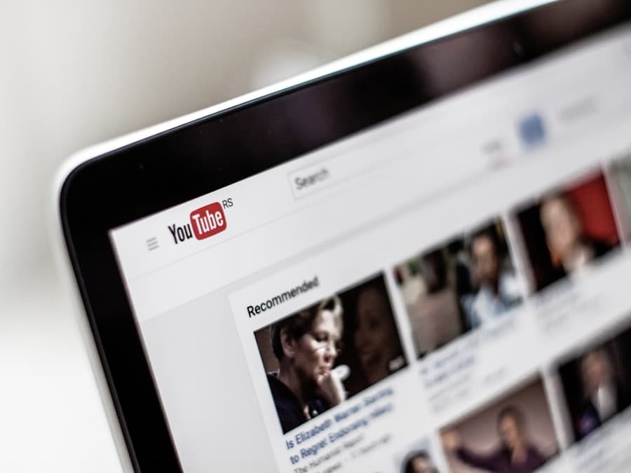 A laptop screen showing a list of search results with thumbnails.